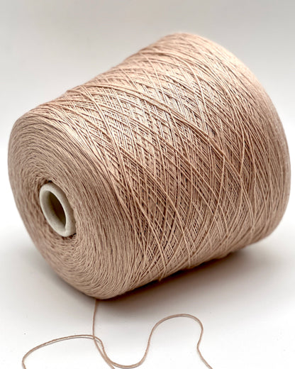Spool of beige yarn on a white background