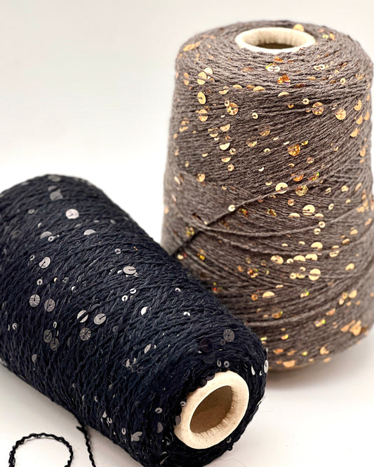 Two spools of yarn with sequin embellishments on a white background
