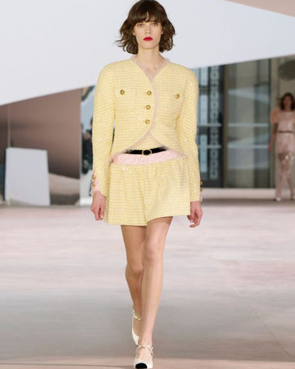 Model wearing a yellow outfit on a runway
