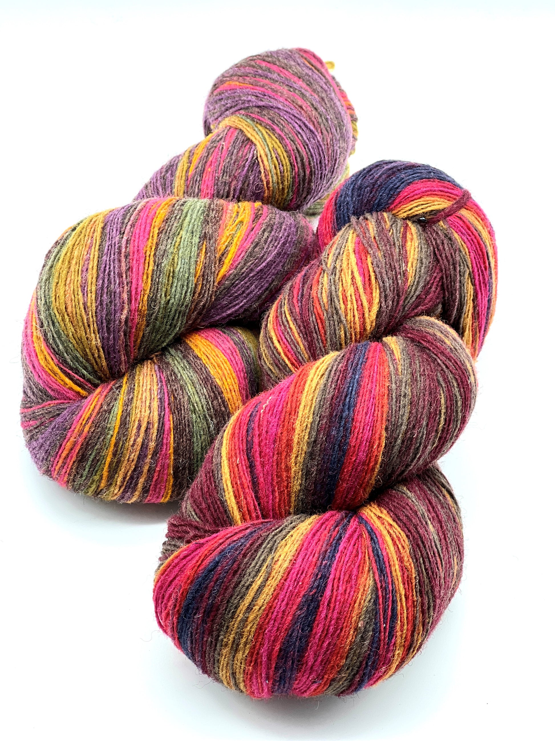 Small-batch dyed heritage skeins of 100% Latvian Dark-Headed Sheep Wool in earthy multicolor gradients like Green-Brown #052. The image shows the rustic single-ply texture and the sheep breed origin, representing the authentic wool traditions of Paces Vilnas Fabrika, Latvia. Available at iDOKNiT.com.