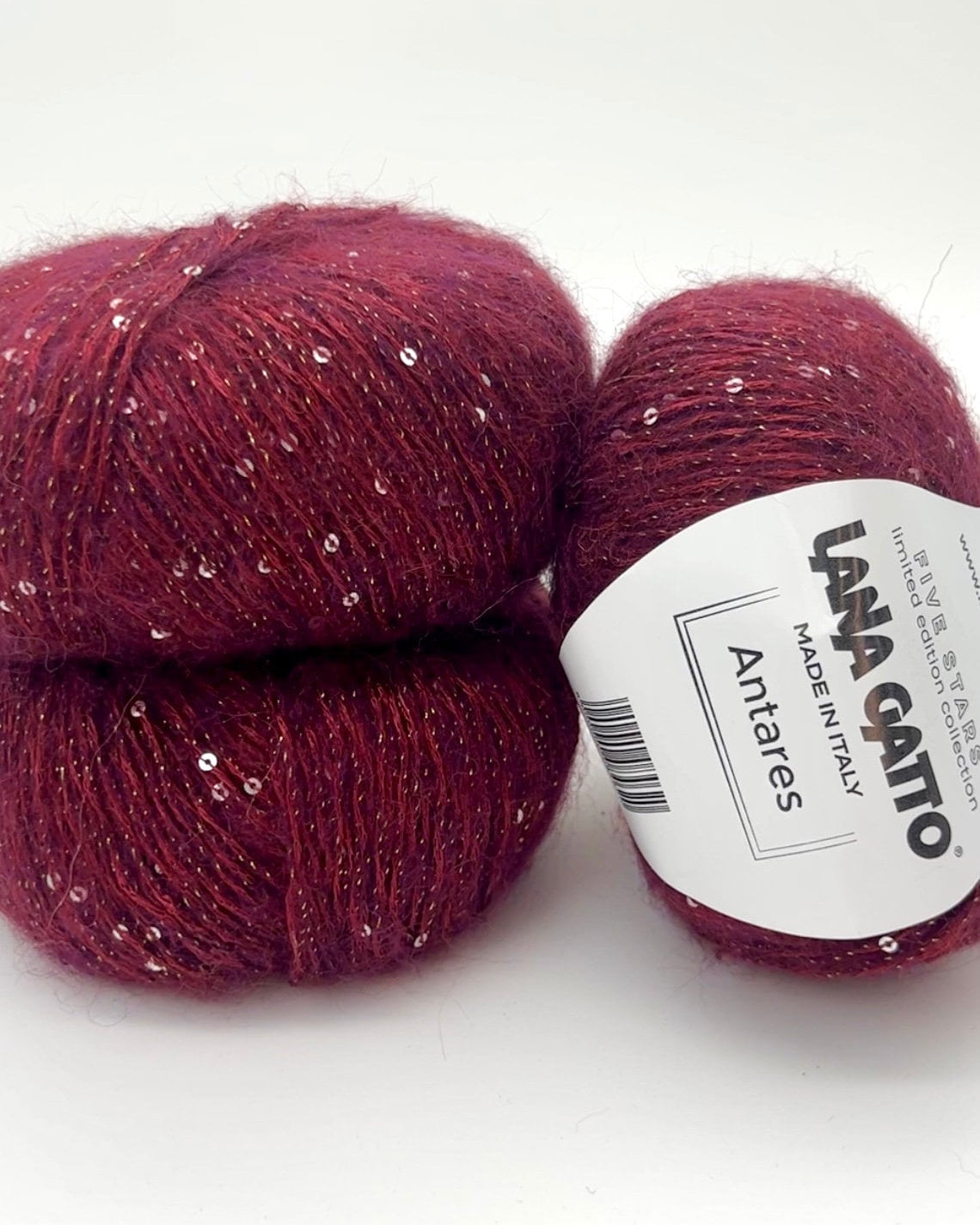 Two balls of red yarn with a label on a white background