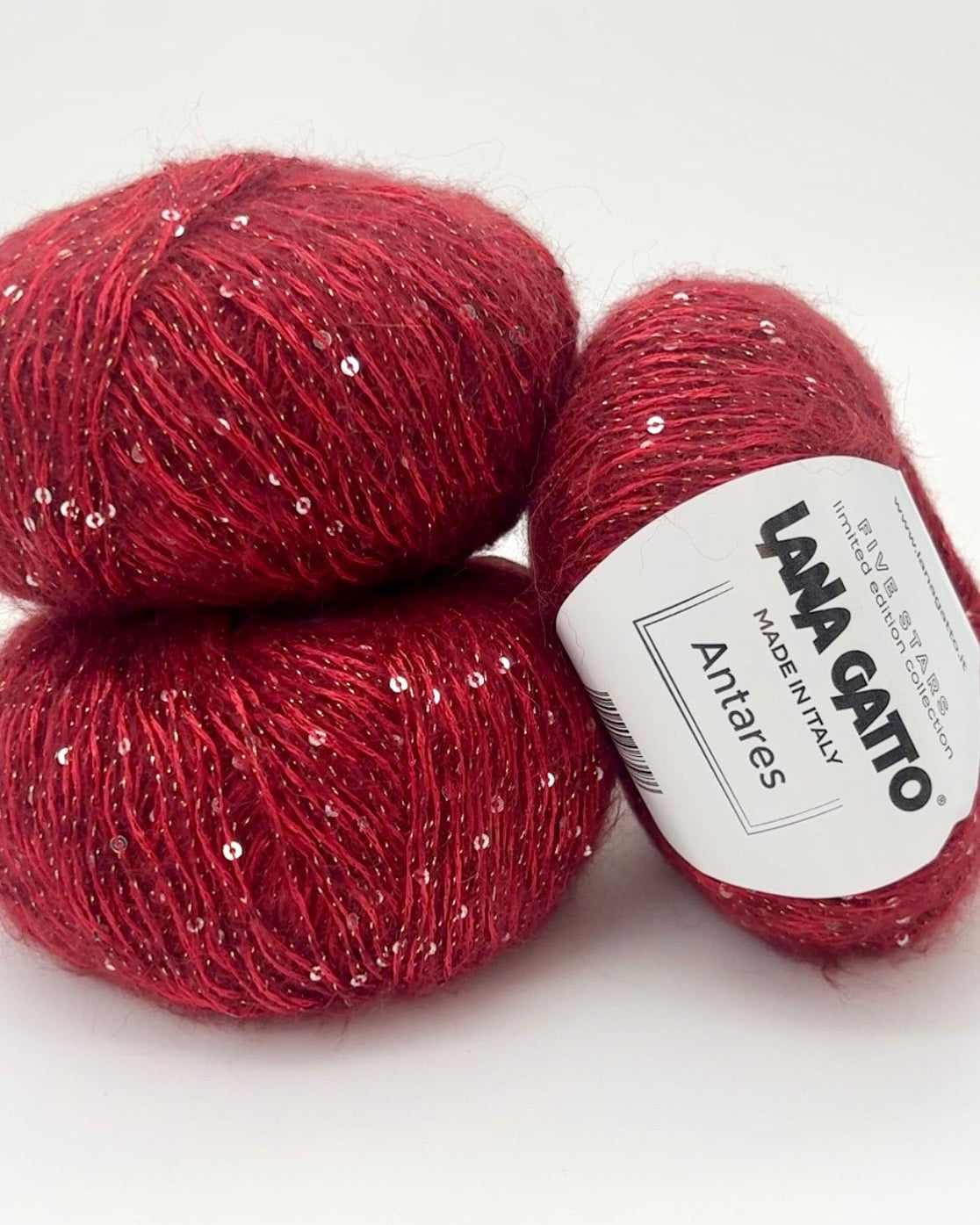 Red yarn balls with a visible label on a white background