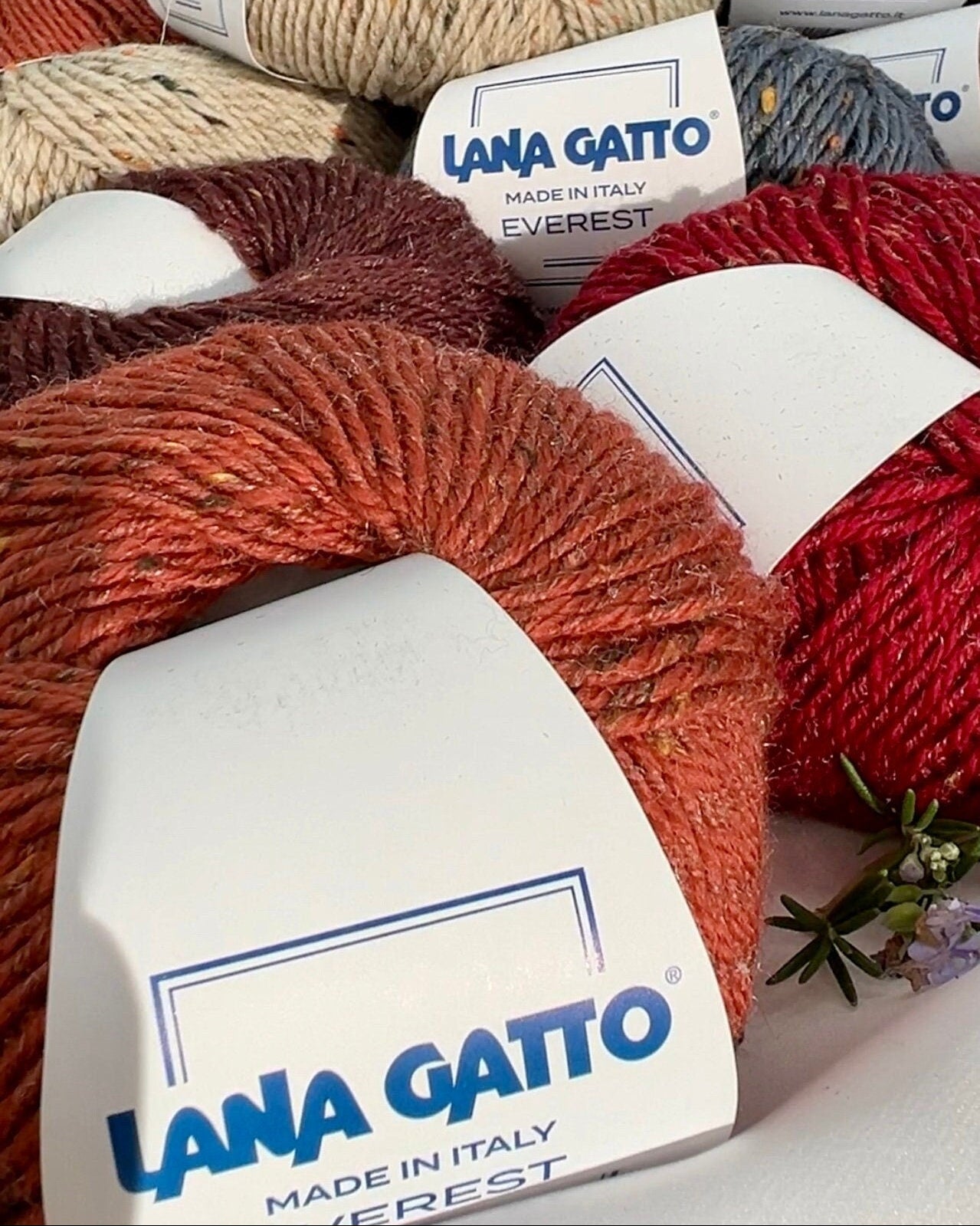 Close-up of iDOKNiT Lana Gatto EVEREST tweed yarn, showing the rustic texture of the Merino and Viscose blend with signature colorful neps in a 50g ball.