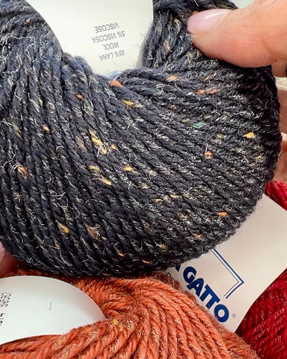 Close-up of iDOKNiT Lana Gatto EVEREST tweed yarn, showing the rustic texture of the Merino and Viscose blend with signature colorful neps in a 50g ball.