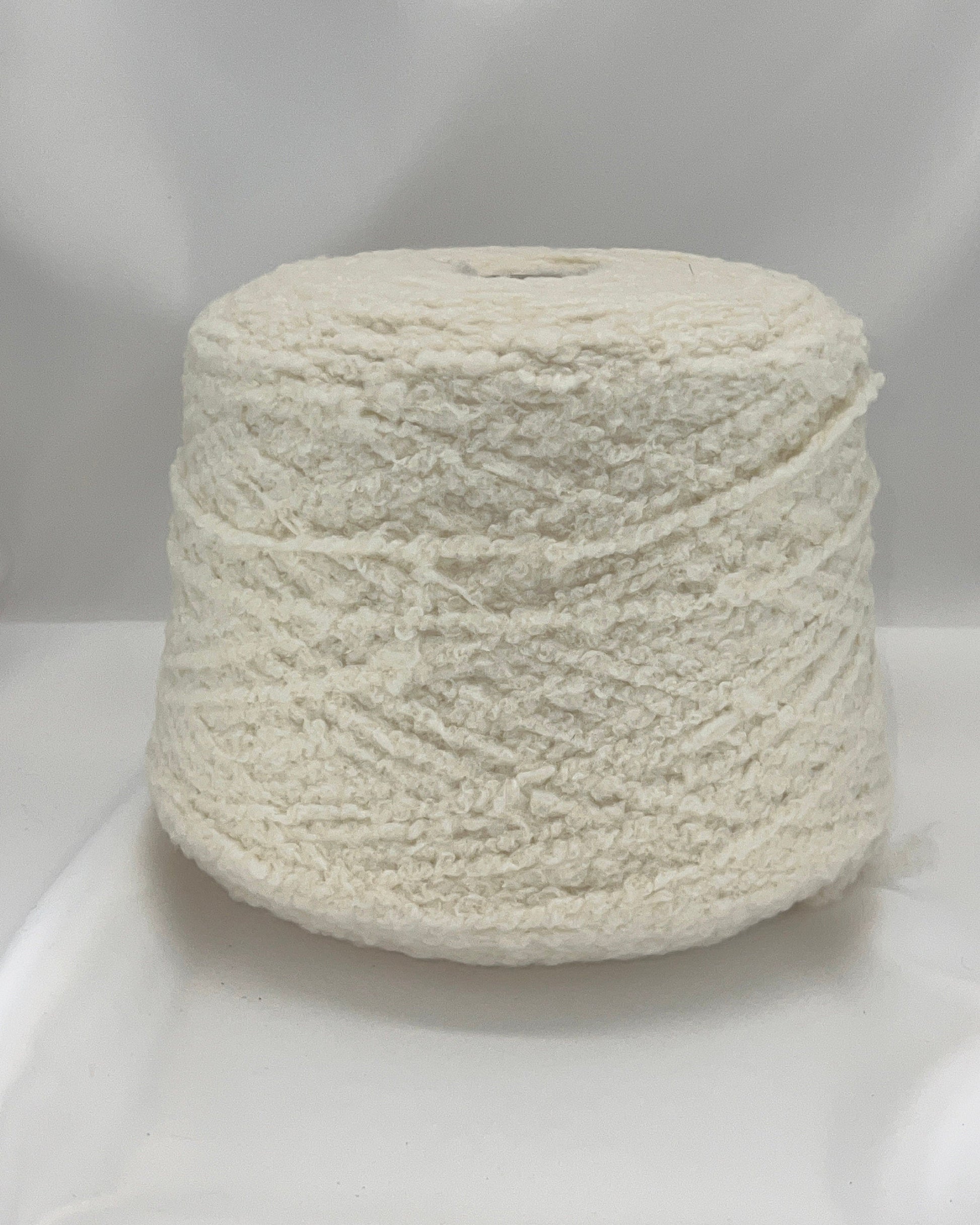 Spool of white yarn on a white background