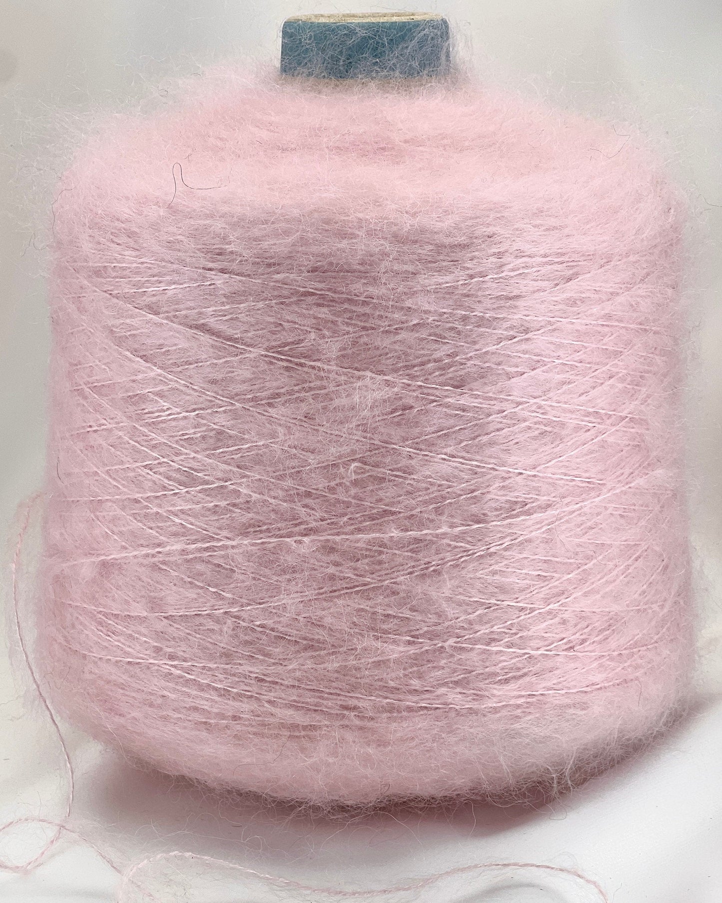 Pink yarn spool on a light gray background