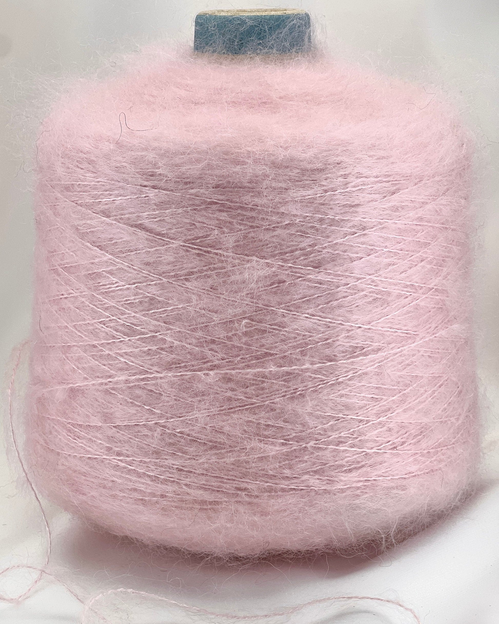 Pink yarn spool on a light gray background
