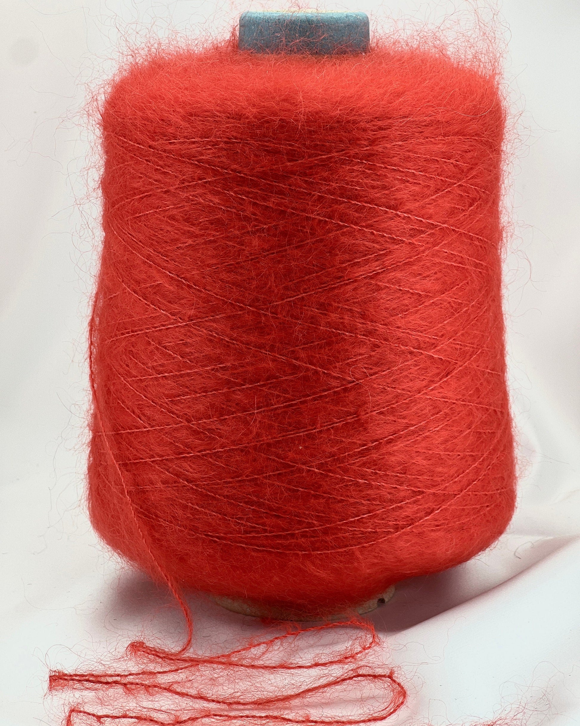 Spool of red yarn on a white background