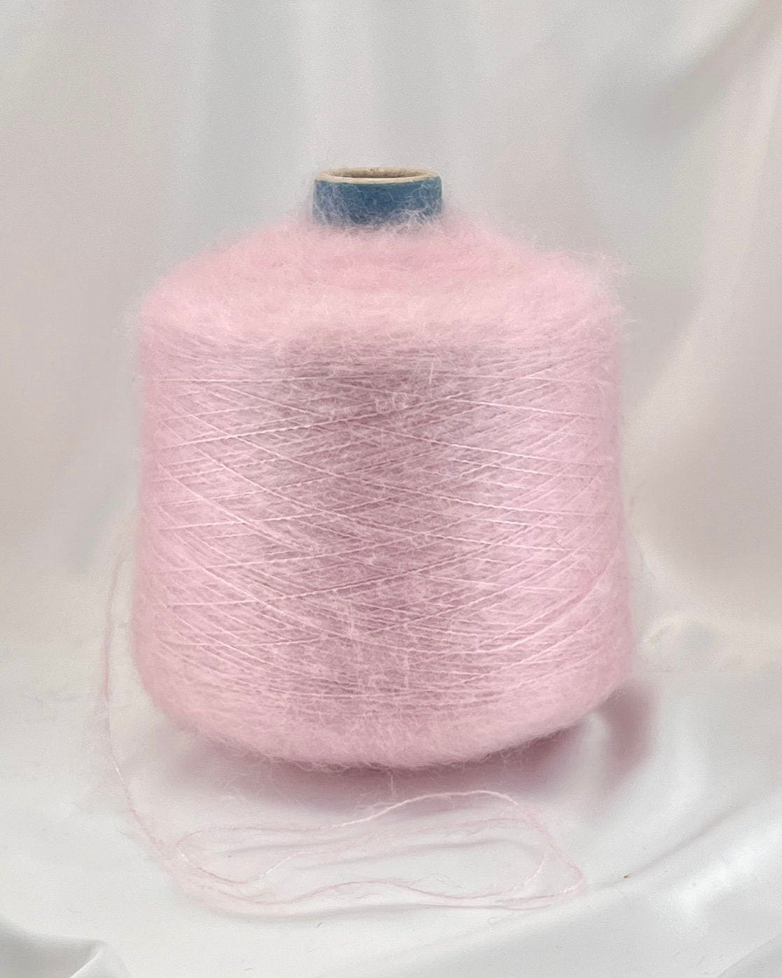 Pink yarn cone on a white background