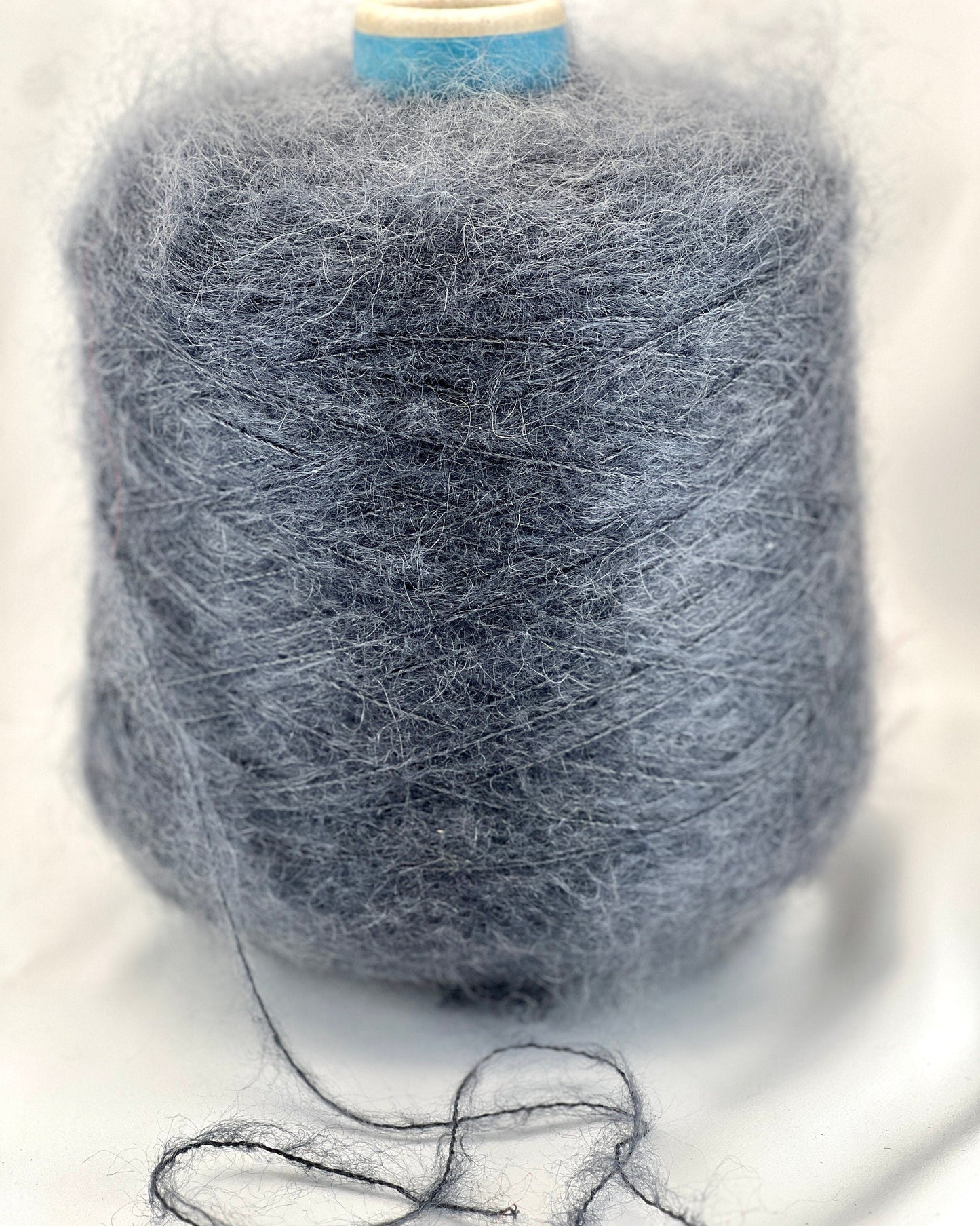 Spool of gray yarn on a white background
