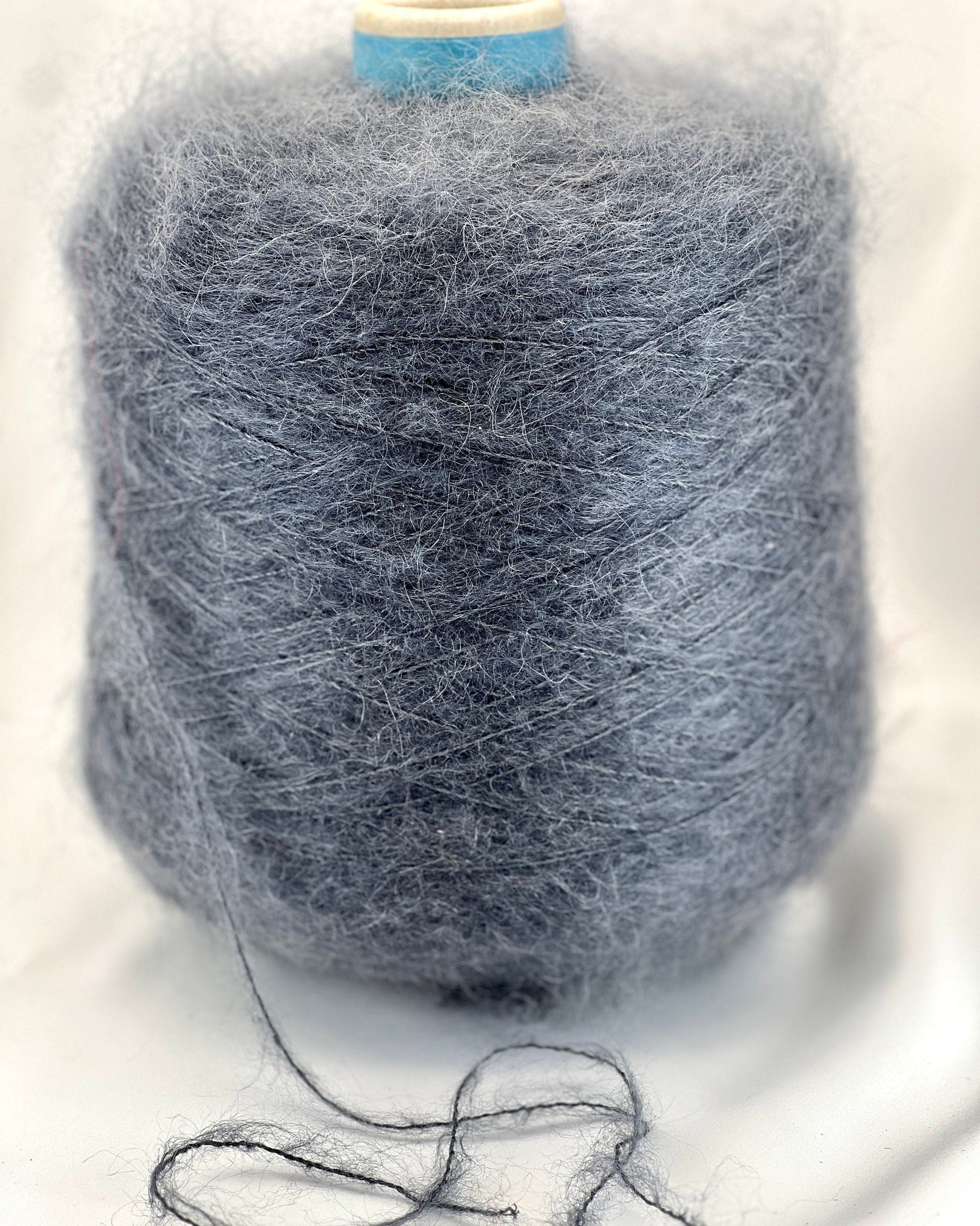 Spool of gray yarn on a white background
