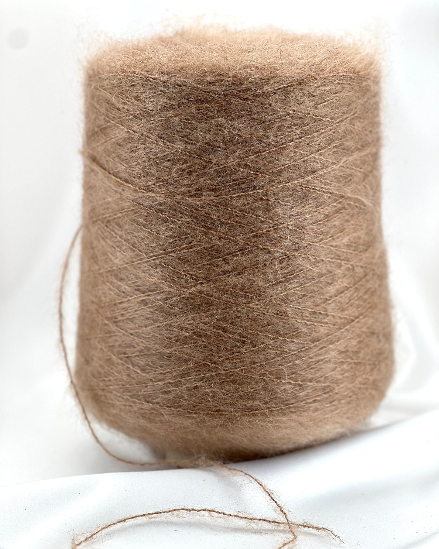 Spool of brown yarn on a white background