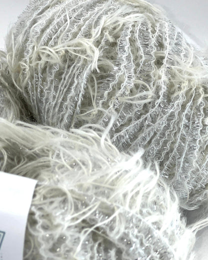 Close-up of a ball of white yarn with a visible brand label.