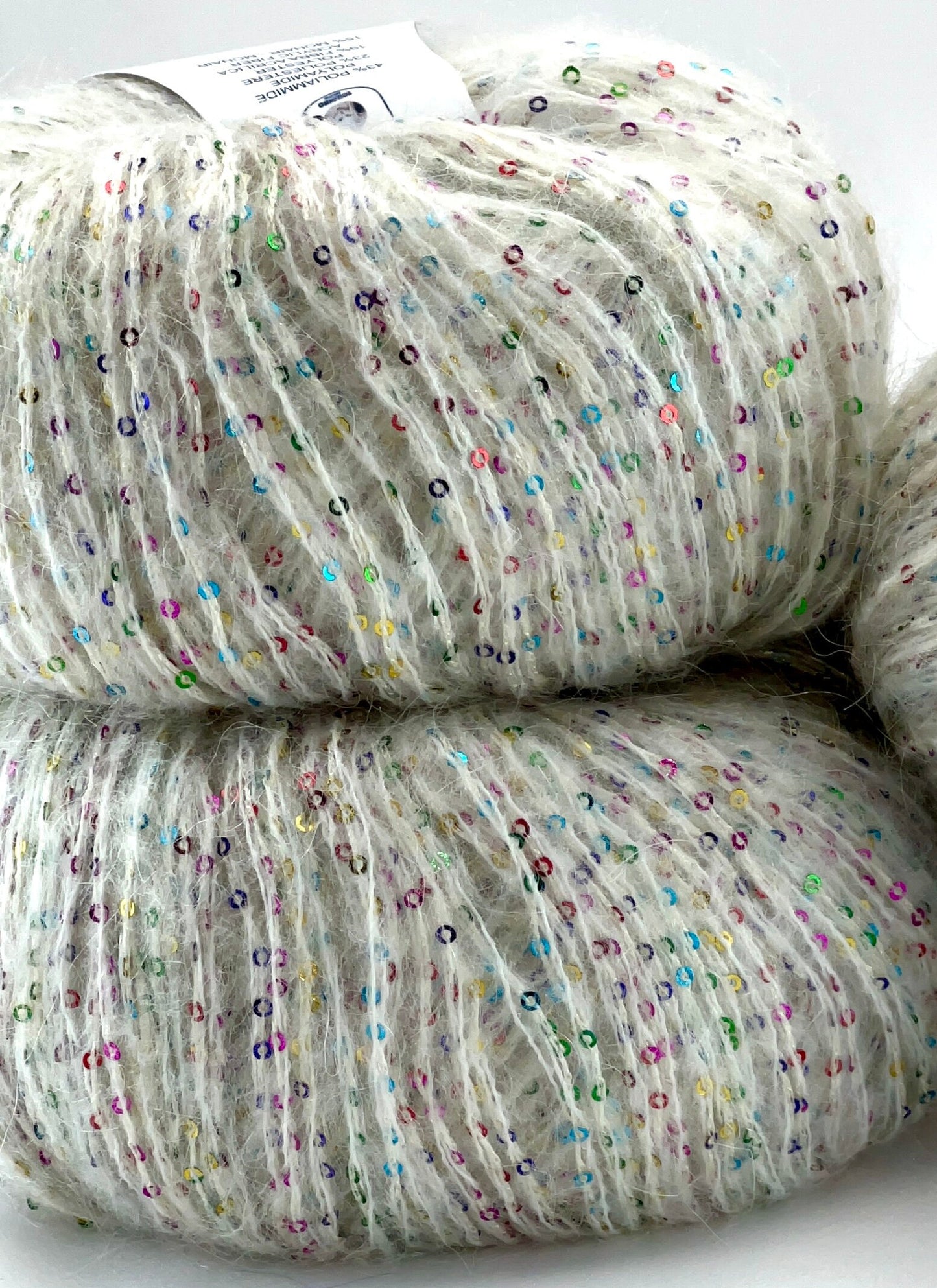 Two skeins of yarn with multicolored speckles on a white background