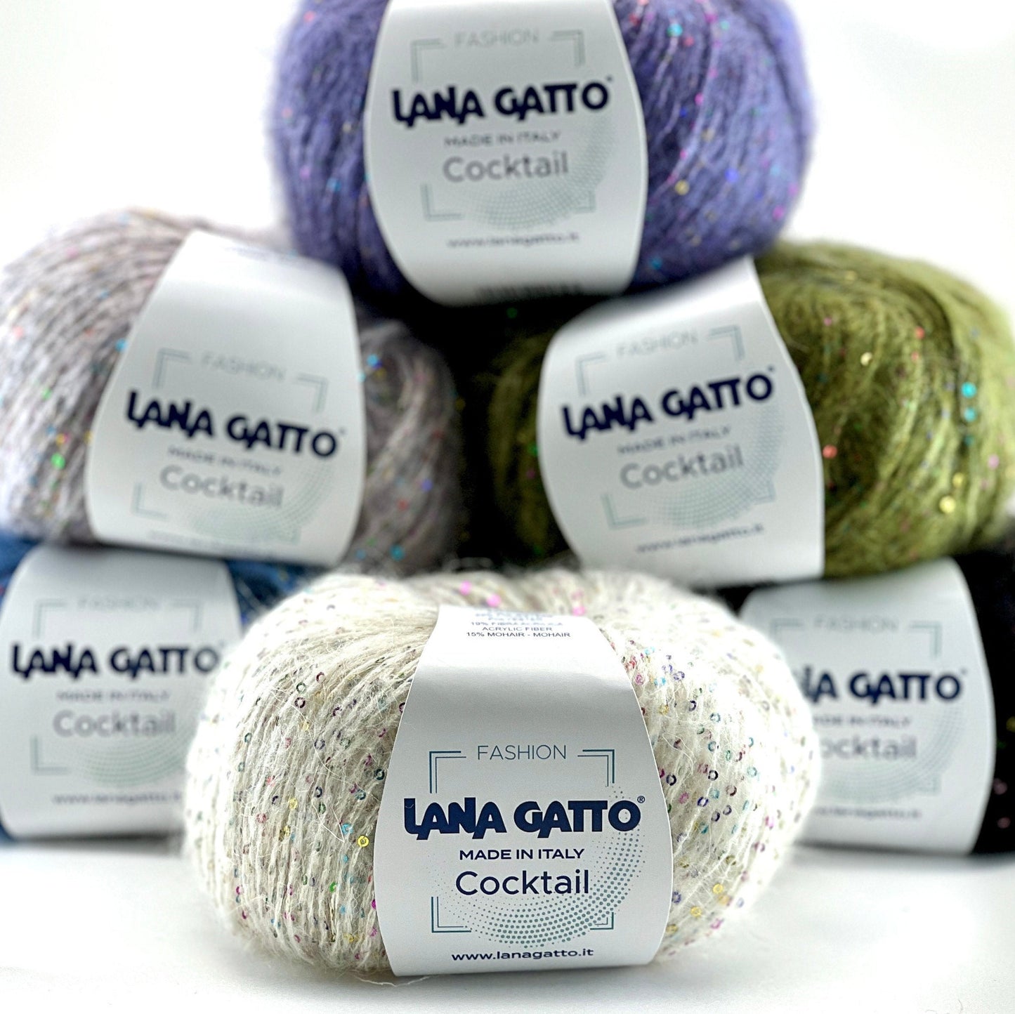 Piles of Lana Gatto yarn with visible labels on a white background