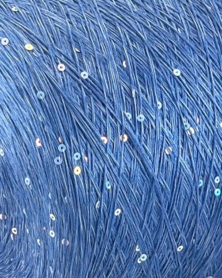 Close-up of blue yarn with small white and pink specks