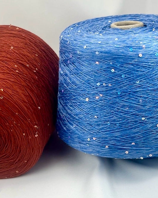 Two spools of yarn, one red and one blue with glitter, on a white background.