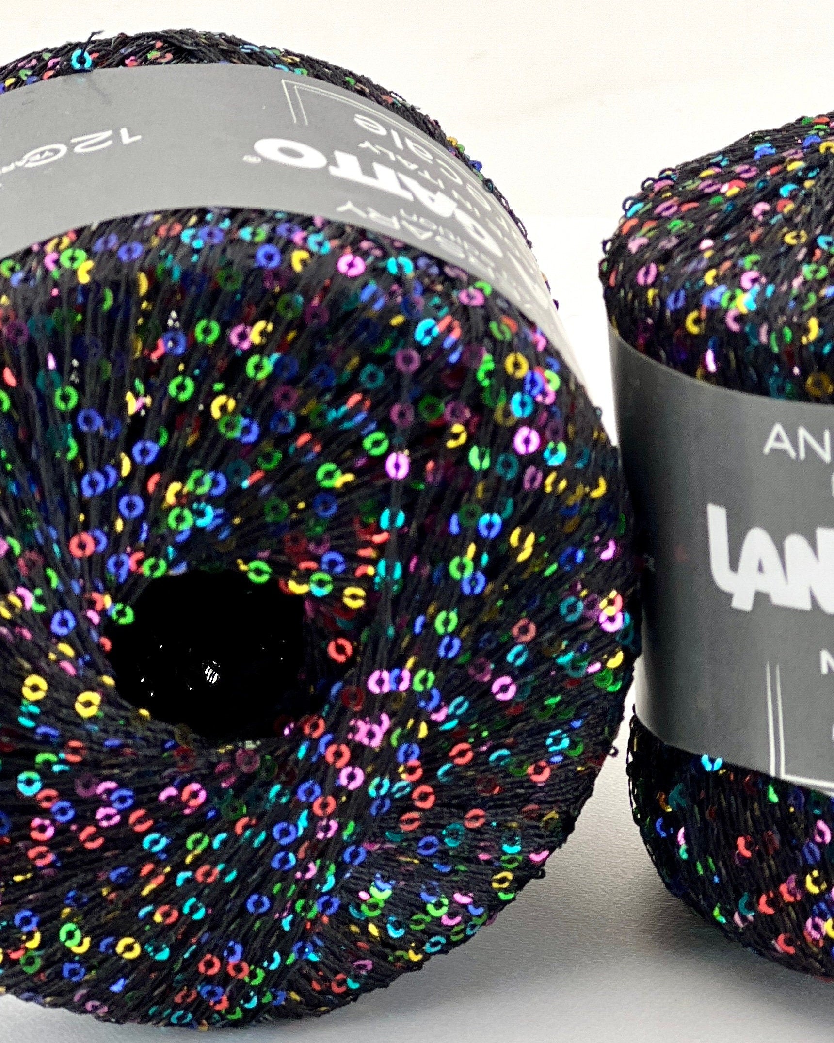 Multicolored yarn ball with 'LANA Grossi' label on a white background