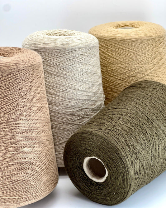 Loro Piana 100% Extra Fine Cashmere lace yarn (2/27 Nm) on a professional cone. Shown in classic neutral shades including Light Camel, Sand Melange, and Ivory. Made in Italy. Available at iDOKNiT.com.