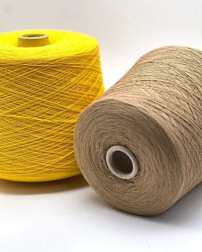 Two spools of yarn, one yellow and one beige, on a white background.