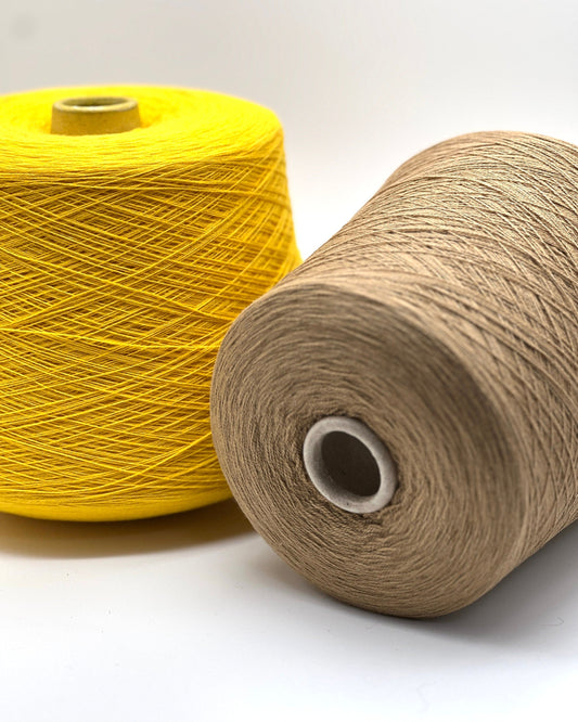 Two spools of yarn, one yellow and one beige, on a white background.