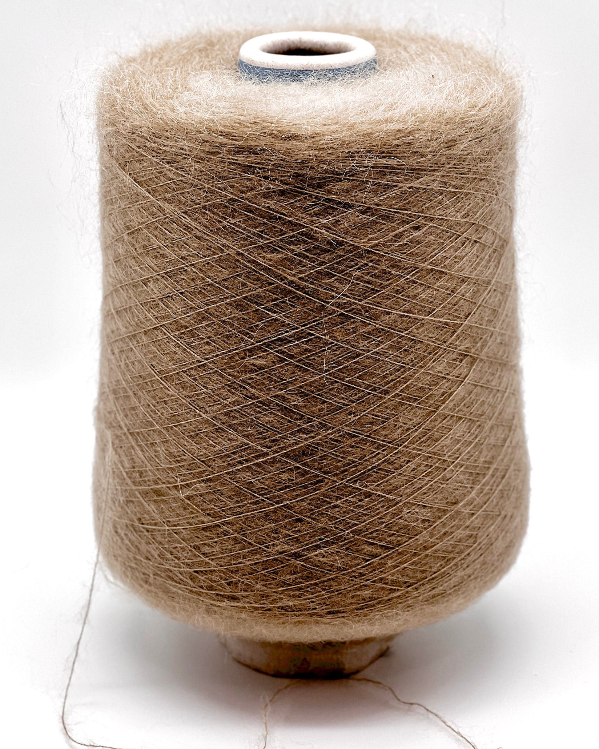 Spool of brown yarn on a white background