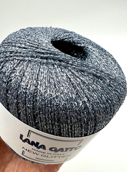 Ball of yarn with glittery texture and 'Lana Grossa' label on a white background
