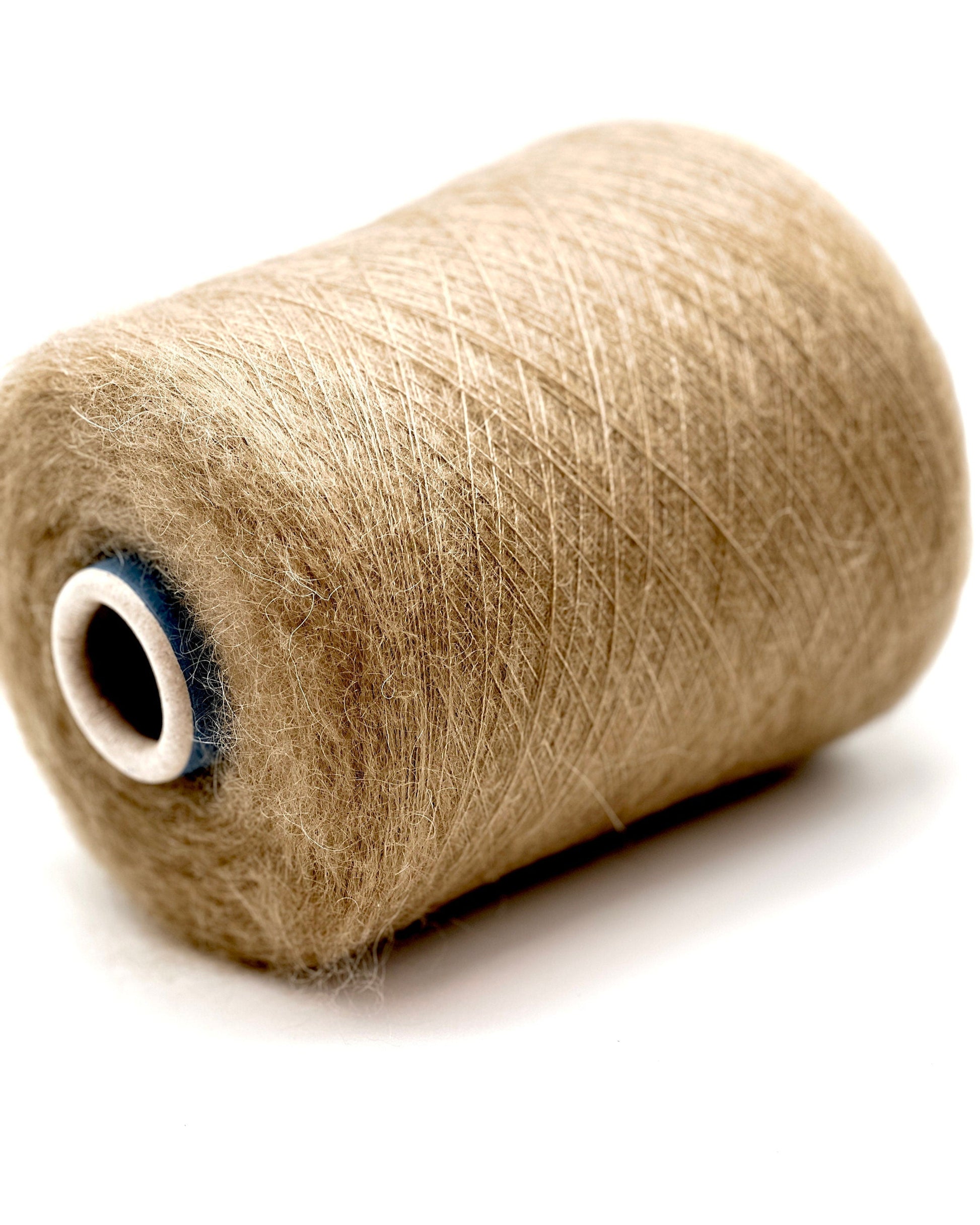 Spool of beige thread on a white background