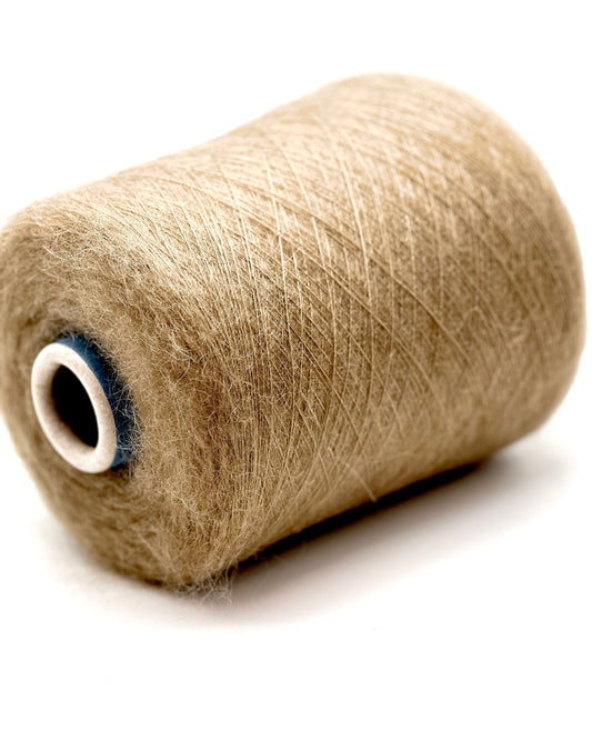 Spool of beige thread on a white background