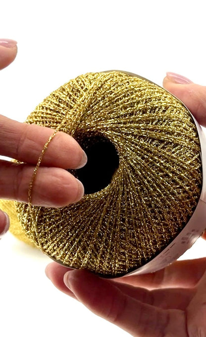 Gold metallic ribbon roll held by hands against a white background