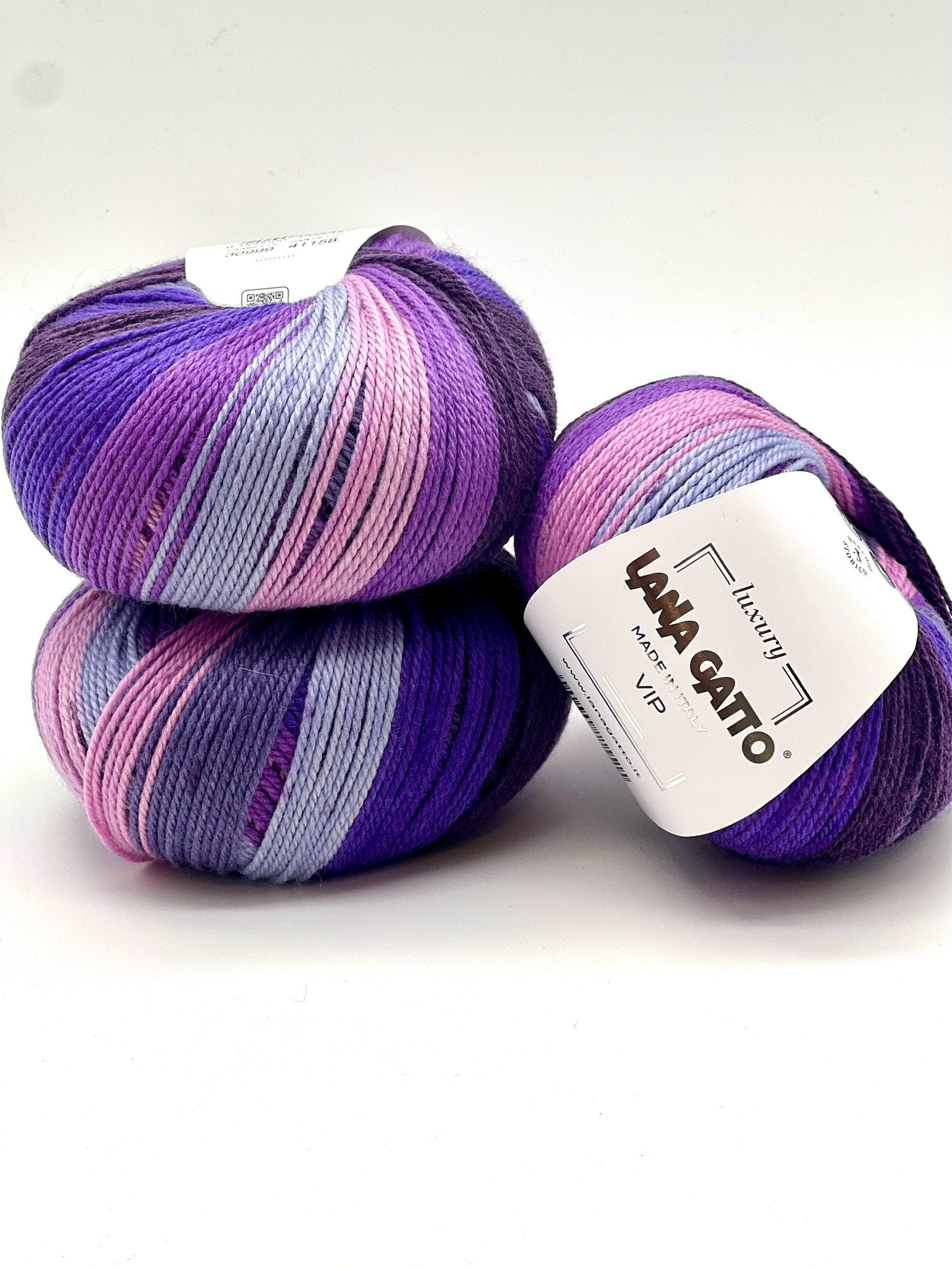Two skeins of purple and pink yarn with 'Lana Grossa' labels on a white background