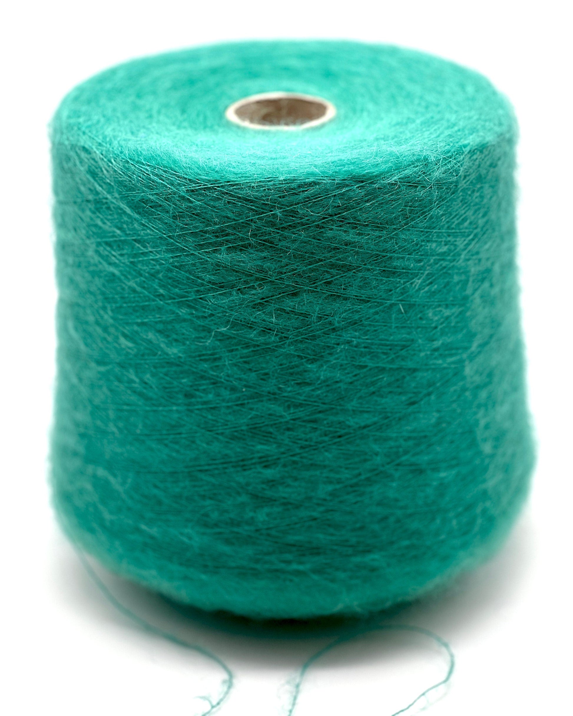 Turquoise yarn spool on a white background