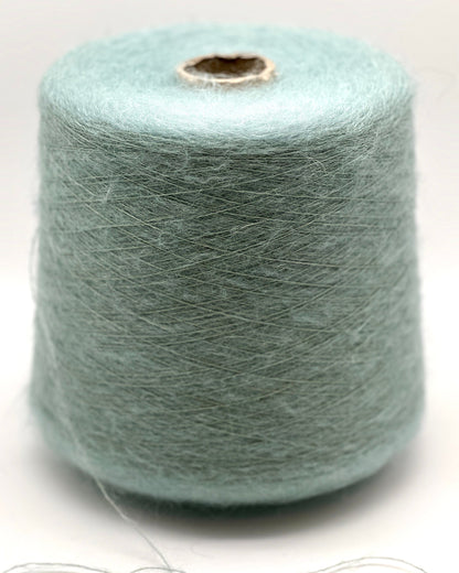 Spool of light blue yarn on a white background