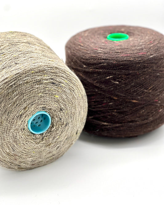 Two spools of yarn, one beige and one brown, on a white background.