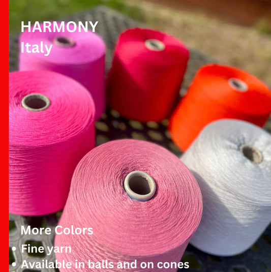 Colorful yarn spools on a black surface with 'Harmony Italy' branding.