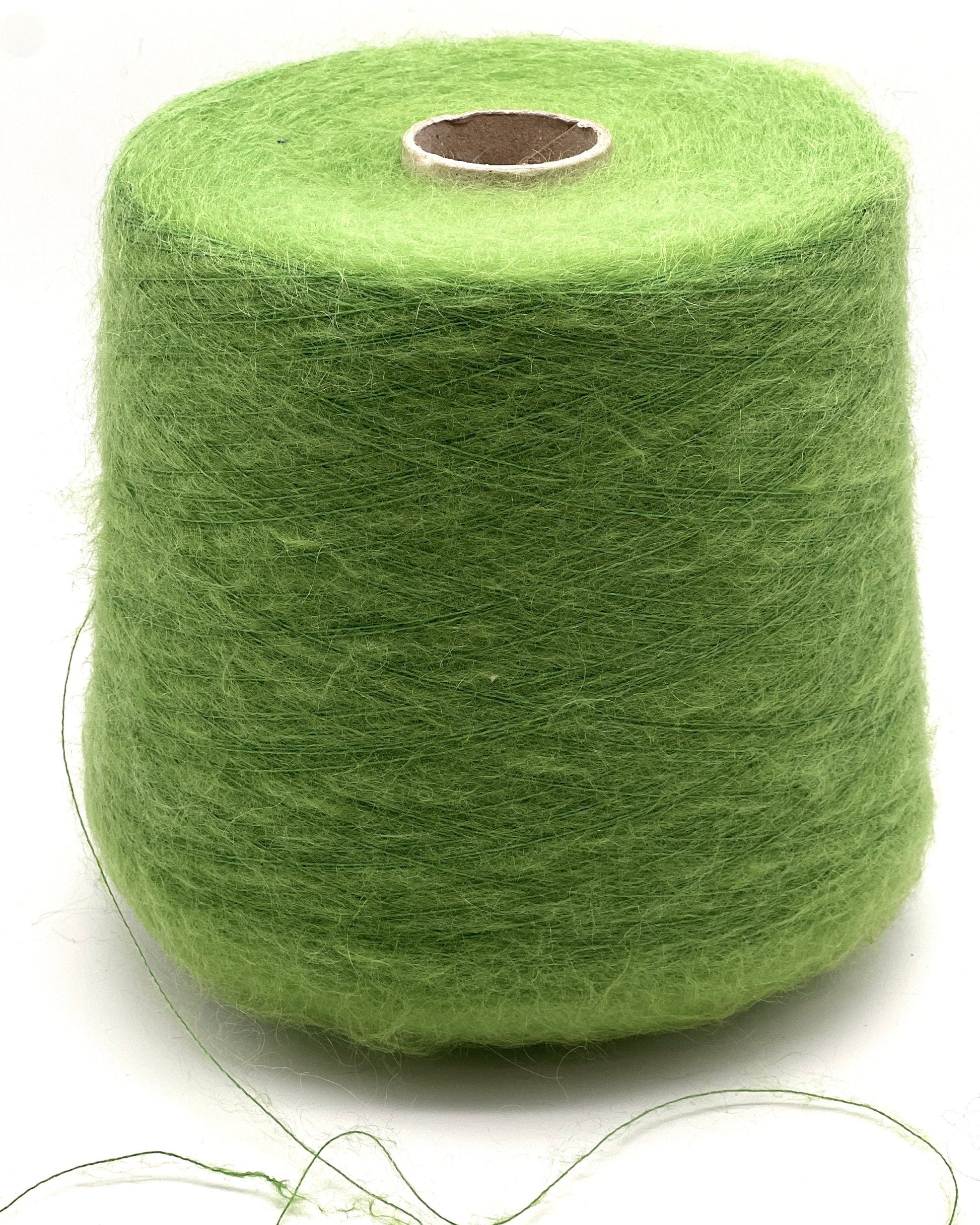 Green spool of yarn on a white background