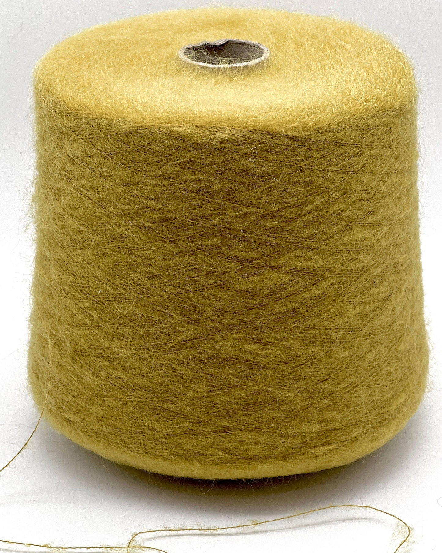 Spool of yellow yarn on a white background
