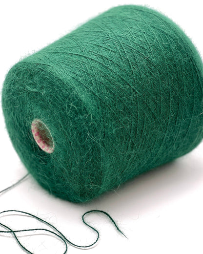 Green yarn spool on a white background