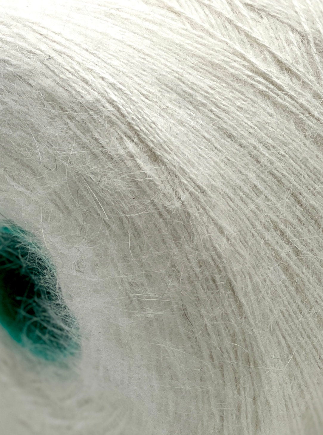 Close-up of white yarn with a small green area