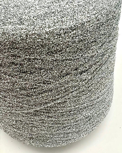 Spool of silver glittery yarn on a white background