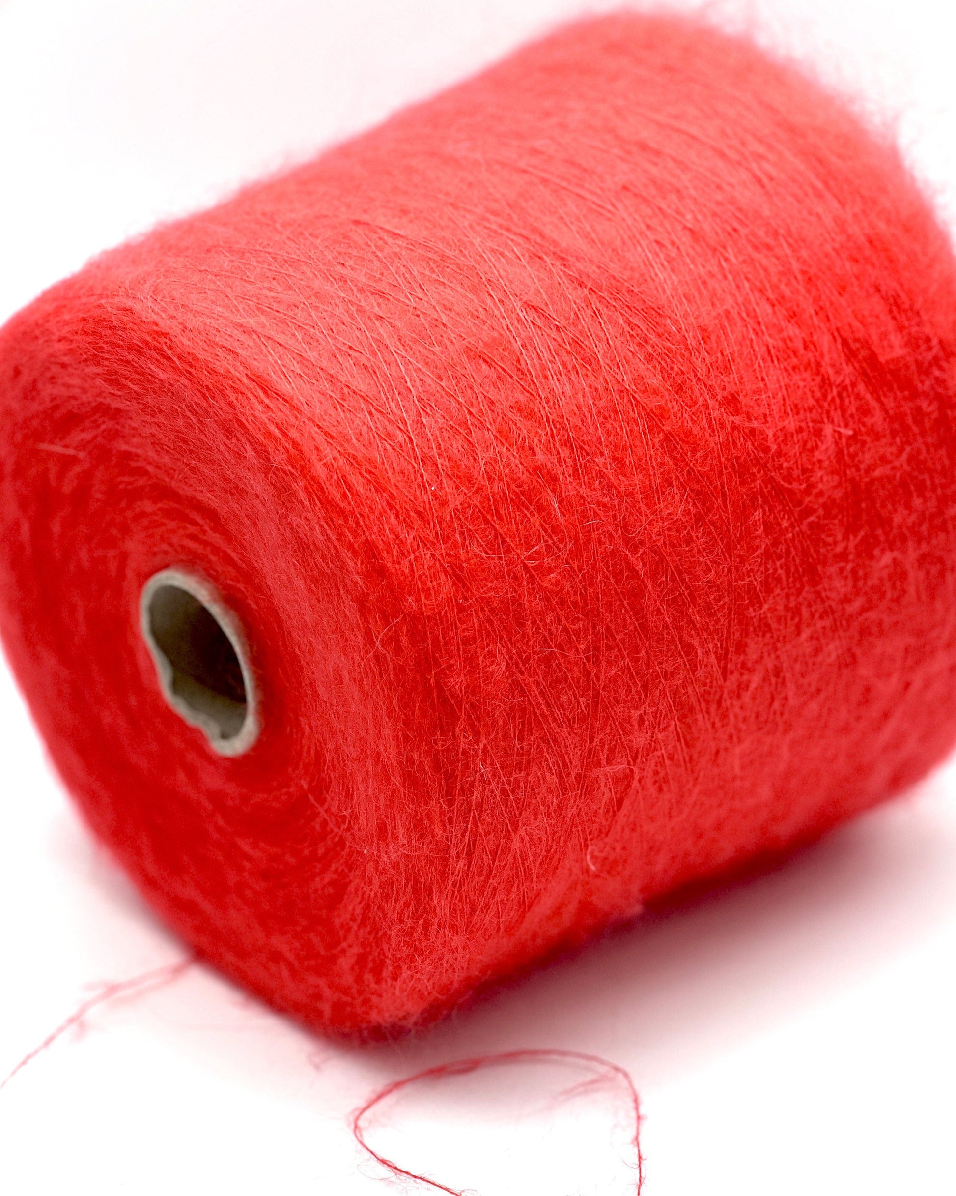 Red spool of thread on a white background