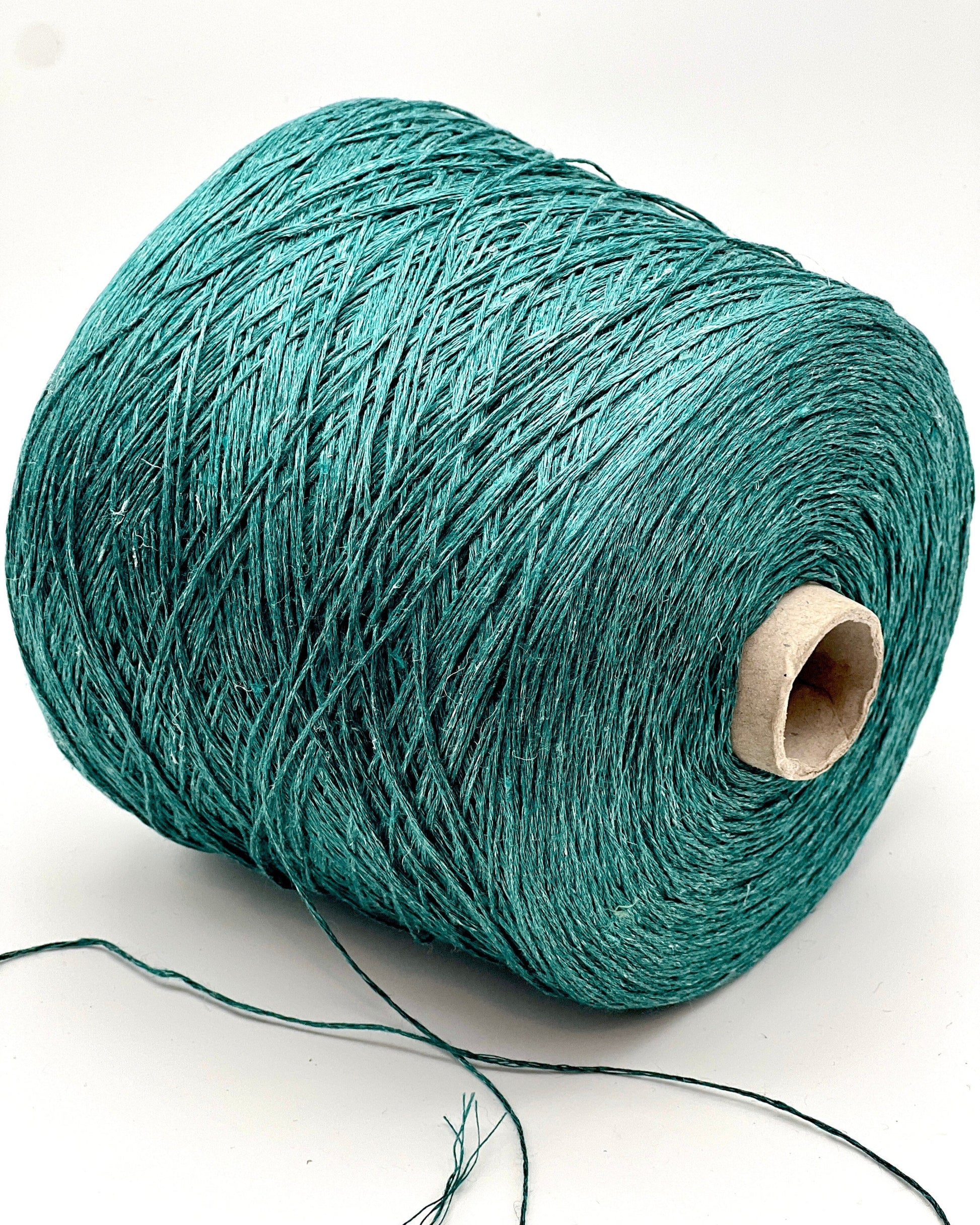 Teal spool of yarn on a white background