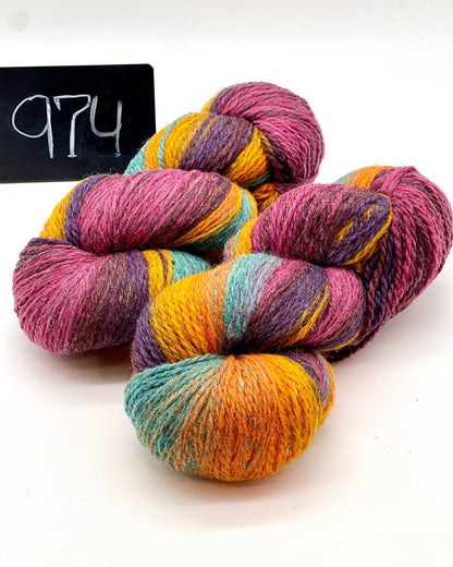 Multicolored skein of yarn on a white background with a black sign displaying '974'.