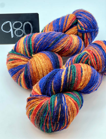 Multicolored yarn skeins on a white background with a black card displaying '980'.