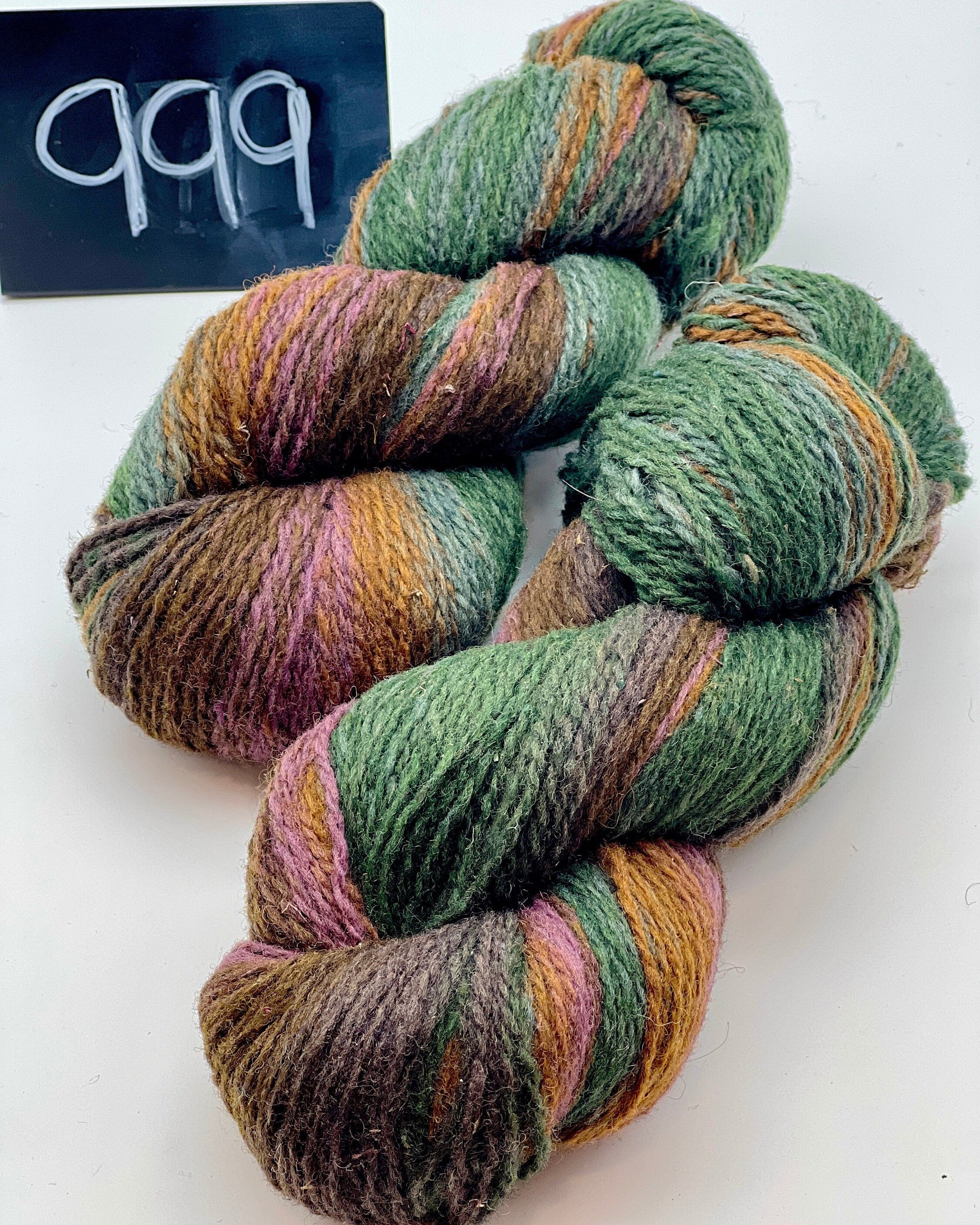 Multicolored yarn skein on a white background with a label reading '999'.
