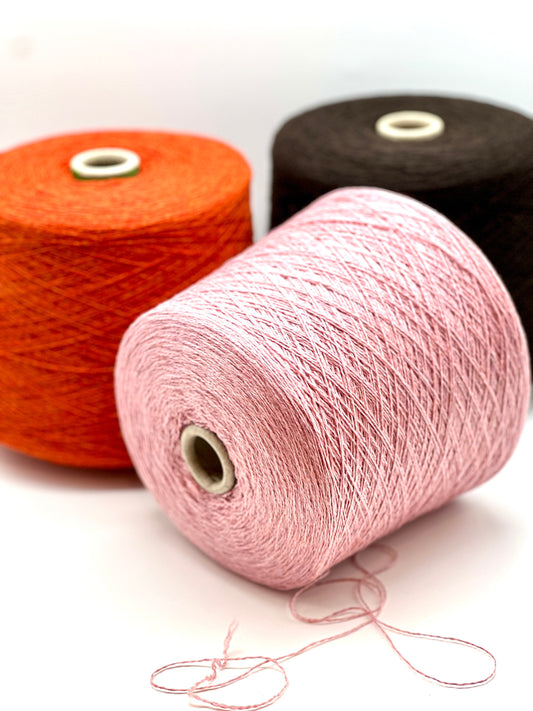 Three spools of yarn in orange, pink, and black on a white background.