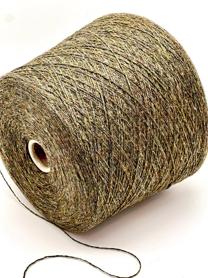 Spool of green yarn on a white background