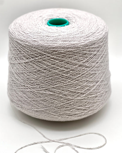 Spool of white yarn on a light gray background