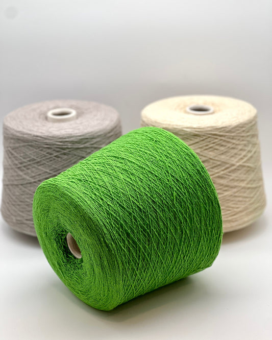 Three spools of yarn in green, gray, and beige on a white background
