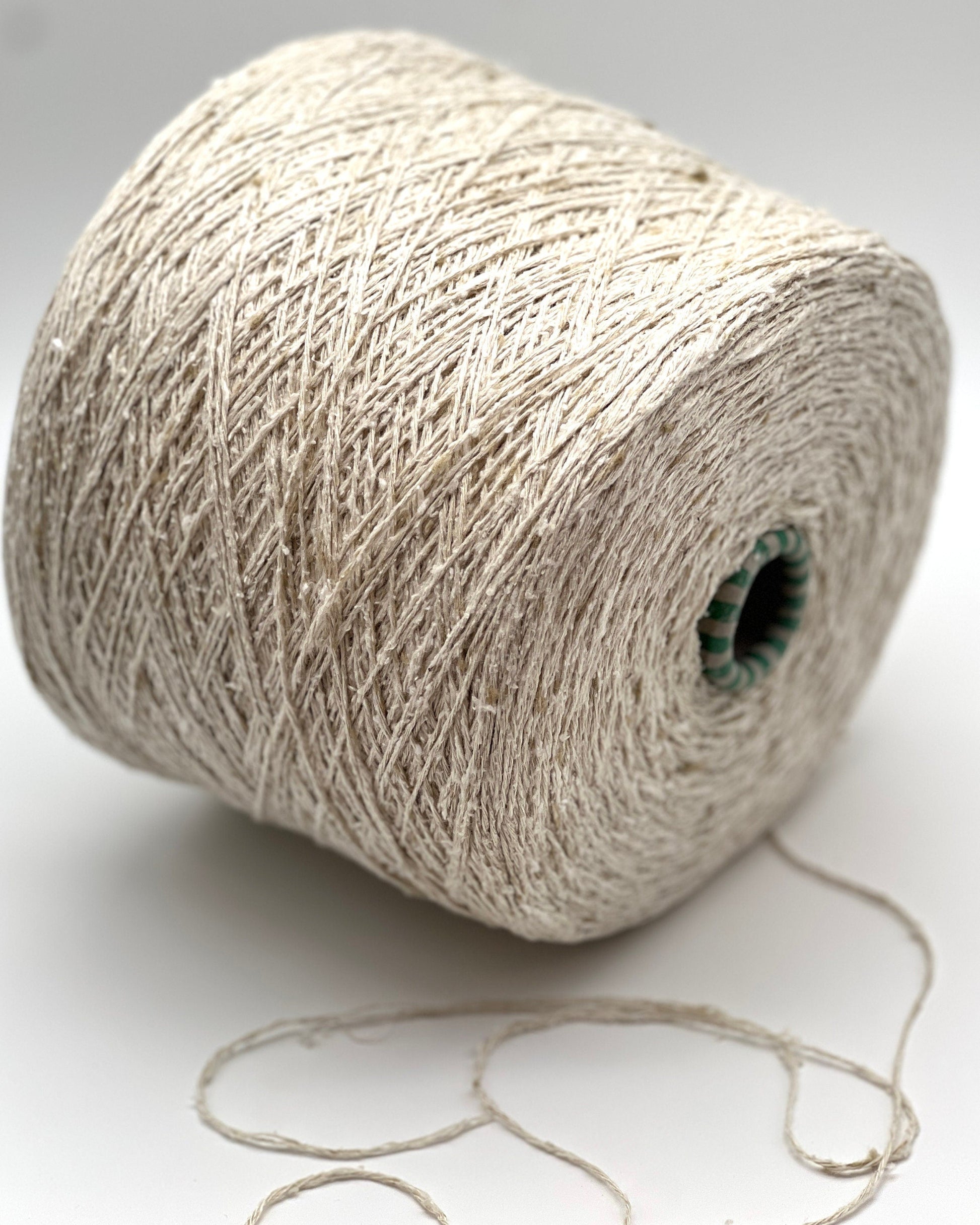 Spool of beige yarn on a white background